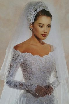 a woman wearing a wedding dress and gloves