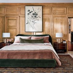 a bedroom with wood paneled walls and a large painting on the wall above the bed