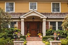 a house with pumpkins and flowers in the front yard