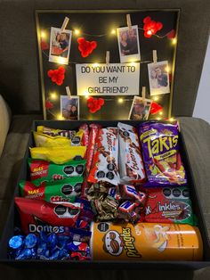 a box filled with candy and candies on top of a couch next to a sign that says do you want to be my girlfriend?