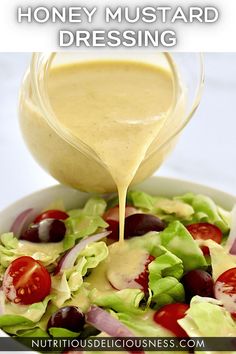 dressing being poured onto a salad with lettuce and tomatoes