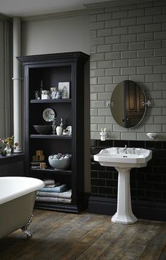 a white bath tub sitting next to a sink in a bathroom under a large mirror