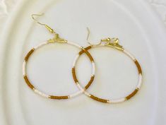 -Gold Hoop Earrings  -Brown and White Glass Beads  -Size 40mm -Earrings come with Gift Box and Backings Brown Beaded Hoop Earrings As Gift, Brown Beaded Hoop Earrings For Gift, Brown Beaded Hoop Earrings, Beaded Hoop Earrings, Beaded Hoops, Jewelry Earrings Hoops, Gold Hoop, Gold Hoop Earrings, White Glass