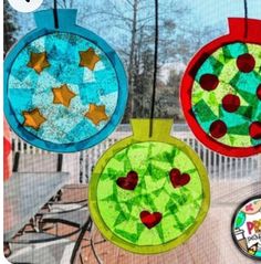 three paper plate ornaments hanging from a window