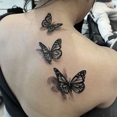 three butterflies on the back of a woman's shoulder