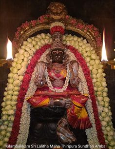 the statue is decorated with flowers and candles