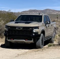 a silver truck is parked in the desert