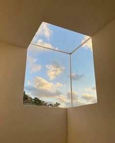 an empty room with a skylight in the center and clouds above it, as seen from inside