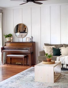 a living room filled with furniture and a piano in front of a mirror on the wall