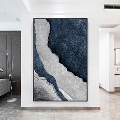 an abstract painting hangs on the wall next to a couch in a modern living room