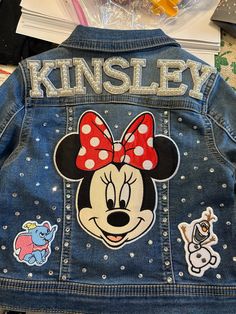 a denim jacket with mickey mouse patches on it