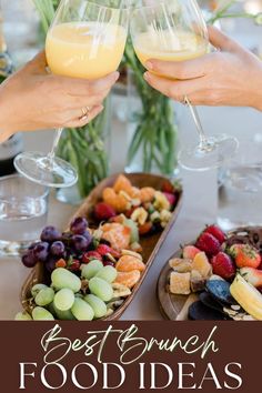 two people toasting wine glasses over food