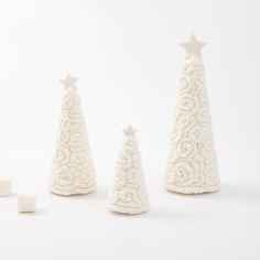 three small white christmas trees with stars on them