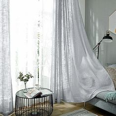 a living room filled with furniture and white curtains