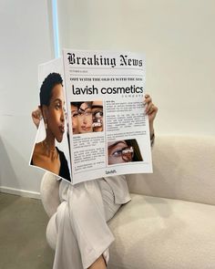 a woman sitting on a couch holding up a news paper with photos of her face