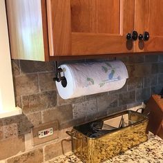 a kitchen counter top with a roll of toilet paper on it and a wooden cabinet