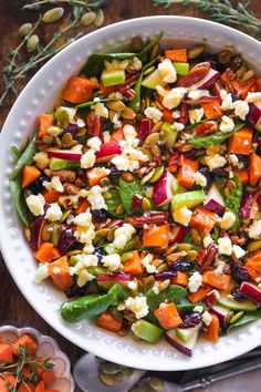 a salad with carrots, celery and other vegetables in a white bowl