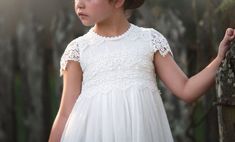 This dress is stunning! It's perfectly detailed and simply elegant. The bodice is layered with soft lace trim that extends to the back of the dress and finished off with a darling cap sleeve. The skirt has just the right amount of poof by having a built in pettiskirt. Katrina is fully lined with soft cotton, so never scratchy. All of our dresses are tactile friendly for the most sensitive of children. This is a timeless, elegant dress for the most discerning of events. 100% cotton self, 100% sof Fitted Cap Sleeve Dress With Lace Bodice, Fitted Lace Bodice Dress With Cap Sleeves, Fitted Lace Bodice Dress For First Communion, Cap Sleeve Dress With Lace Bodice, Fitted Lace Dress With Lace Trim For First Communion, Short Sleeve Lace Dress With Lace Back, Fitted Lace Dress For First Communion In Spring, Spring Fitted Lace Dress For First Communion, Fitted Lace Dress For First Communion Summer