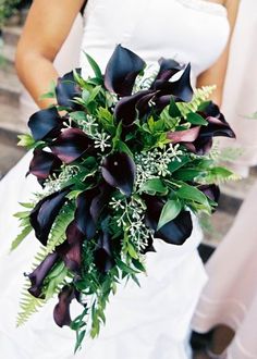 a bride holding a bouquet of flowers in her hand on the steps at their wedding