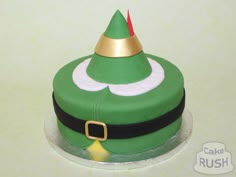 a cake with a green hat and gold trim on it's top that says cake rush