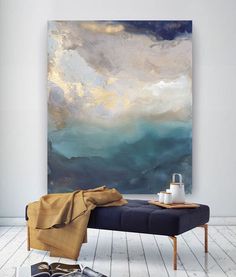 a painting hanging on the wall next to a blue bench in front of a white wall