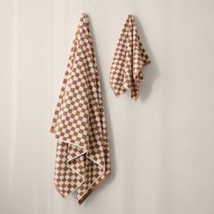 two brown and white checkered towels hanging on the wall