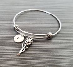 "Personalized Antique Silver Rose Bangle Bracelet! A detailed rose charm on an expandable bangle bracelet makes the perfect gift for you or your best friend. The rose bracelet charm is made from zinc alloy and measures 26 mm by 9 mm. The bangle bracelet is high quality stainless steel and fits a wrist sized 6-8\". The flower bangle bracelet is personalized with a .5\" silver plated disc stamped with the initial of your choice. The charm and initial disc are connected to the bangle with sturdy sp Adjustable Rose Bracelet (gift), Adjustable Rose Bracelet For Gift, Adjustable Rose Bracelets For Gift, Adjustable Rose Bracelets As Gift, Adjustable Rose Flower Bracelet, Adjustable Metal Charm Bracelet With Flower Charm, Adjustable Metal Bracelet With Flower Charm, Flower Charm Bracelet, Bible Verse Bracelet