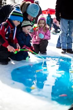 two children playing in the snow with their mom and dad at an outdoor ice rink