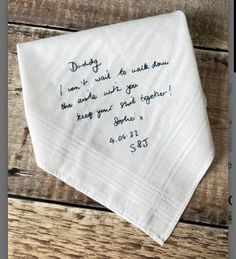 a napkin with writing on it sitting on top of a wooden table