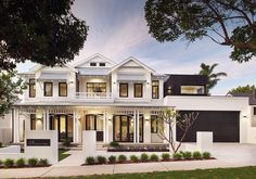 a white two story house with black shutters and trees in the front yard at dusk