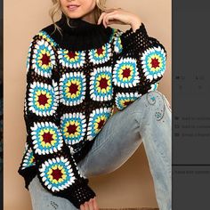 a woman is posing with her hand on her hip wearing a colorful crocheted sweater