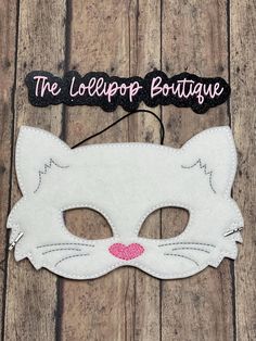 a white cat mask with the words the lollipop boutique on it's forehead