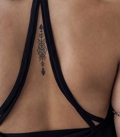 the back of a woman's bra with an arrow tattoo