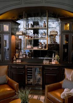 a living room filled with brown furniture and lots of shelves on the wall above it