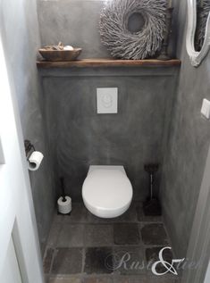 a white toilet sitting in a bathroom next to a window