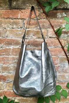 Hobo leather bag in SILVER color laminated leather.  Metallic SILVER leather slouch bag in genuine leather. This shoulder bag is NOT LINED.  Closed with a zipper at the top. base : 27 x 16,5 cm- approx 10 1/2 in x  6 1/2 in Height at the center, without the strap : 33 cm  - approx 13 in Total length  the strap incl. buckles : 42 cm  - approx 16 1/2 in  This bag in different colors and other leather Bags by Good Times Barcelona:  https://www.etsy.com/shop/goodtimesbarcelona?section_id=18820154&re Metallic Rectangular Shoulder Bag For Travel, Metallic Shoulder Bag For Daily Use, Metallic Soft Leather Shoulder Bag For Everyday Use, Chic Metallic Shoulder Bag For Everyday Use, Metallic Leather Shoulder Bag For Everyday, Metallic Rectangular Shoulder Bag With Removable Pouch, Silver Shoulder Bag With Adjustable Strap For On-the-go, Metallic Soft Leather Bag, Chic Silver Hobo Tote Bag