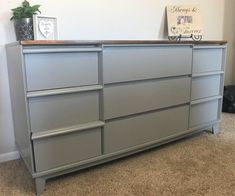 a gray dresser sitting on top of a carpeted floor