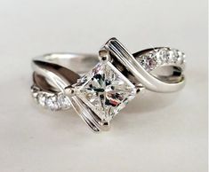 a white gold ring with a princess cut diamond