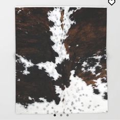 a brown and white cowhide rug with spots on the fur is shown in front of a white wall