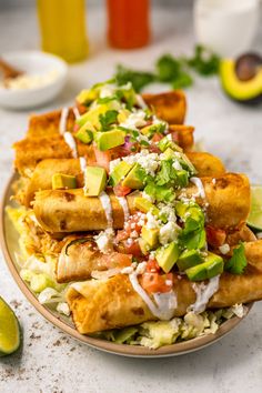 an enchilada dish is served on a plate with limes and cilantro