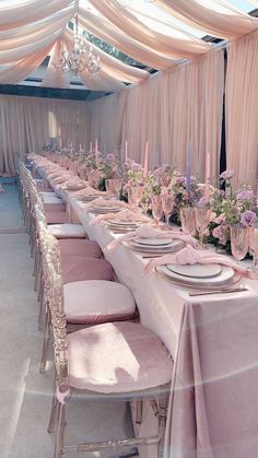 the tables are set with pink linens and place settings for an elegant dinner party