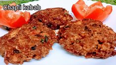 three crab cakes on a white plate with tomatoes