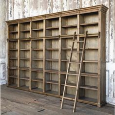 an old wooden bookcase with ladder leaning against it