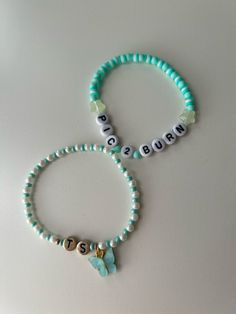 two bracelets with name beads and charms