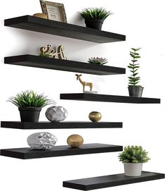 three black floating shelves with plants on them