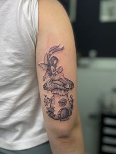 a woman with a tattoo on her arm holding onto a clock and mushrooms in the background