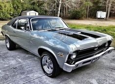 an old muscle car parked in a driveway