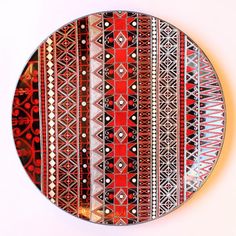 a red and black plate sitting on top of a white table next to a wall