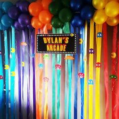 balloons and streamers are hanging from the ceiling in front of a sign that reads dylan's arcade