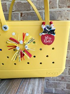 a yellow handbag with pins attached to it